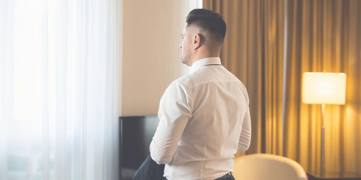 Man dressing white tie in his hotel room