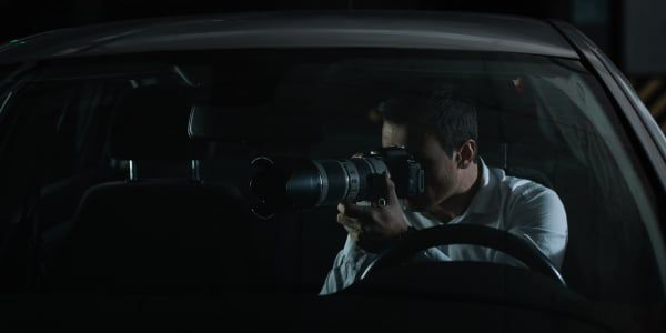 surveillance, man spies on building by filming from his car